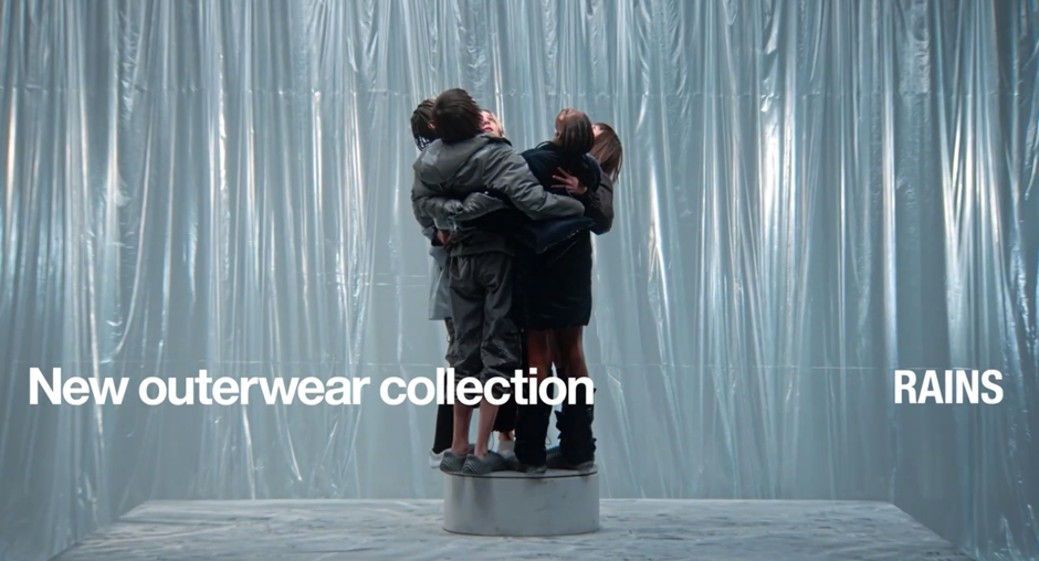 Four people wearing RAINS products hugging